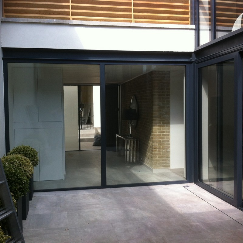 Floor-to-ceiling sliding doors opening to courtyard in Banstead