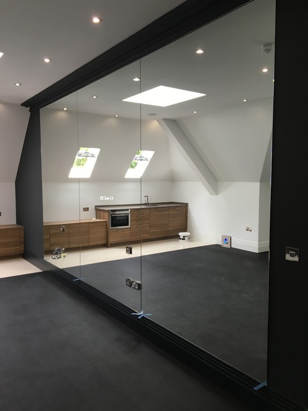 Frameless glass partition in loft conversion by Banstead glaziers